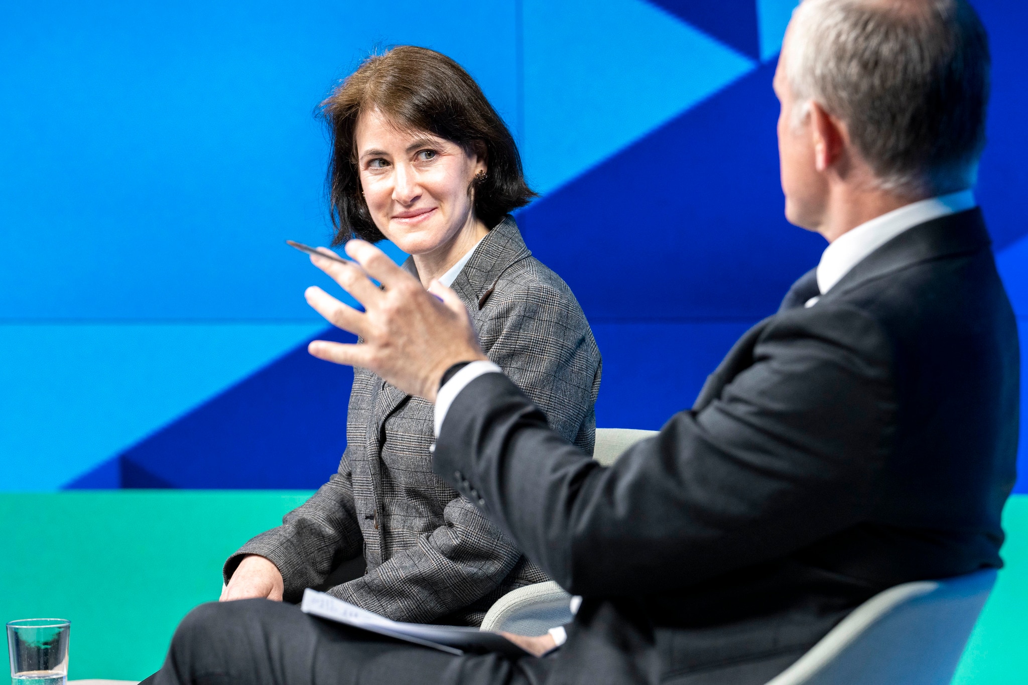 A woman on stage looking a man talking